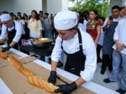 Elaboran en Cancún la torta de cochinita más larga, en busca de récord Guinness